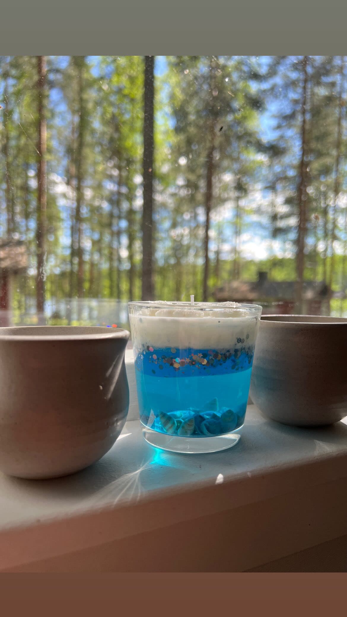 A customer’s ocean-themed candle on a windowsill