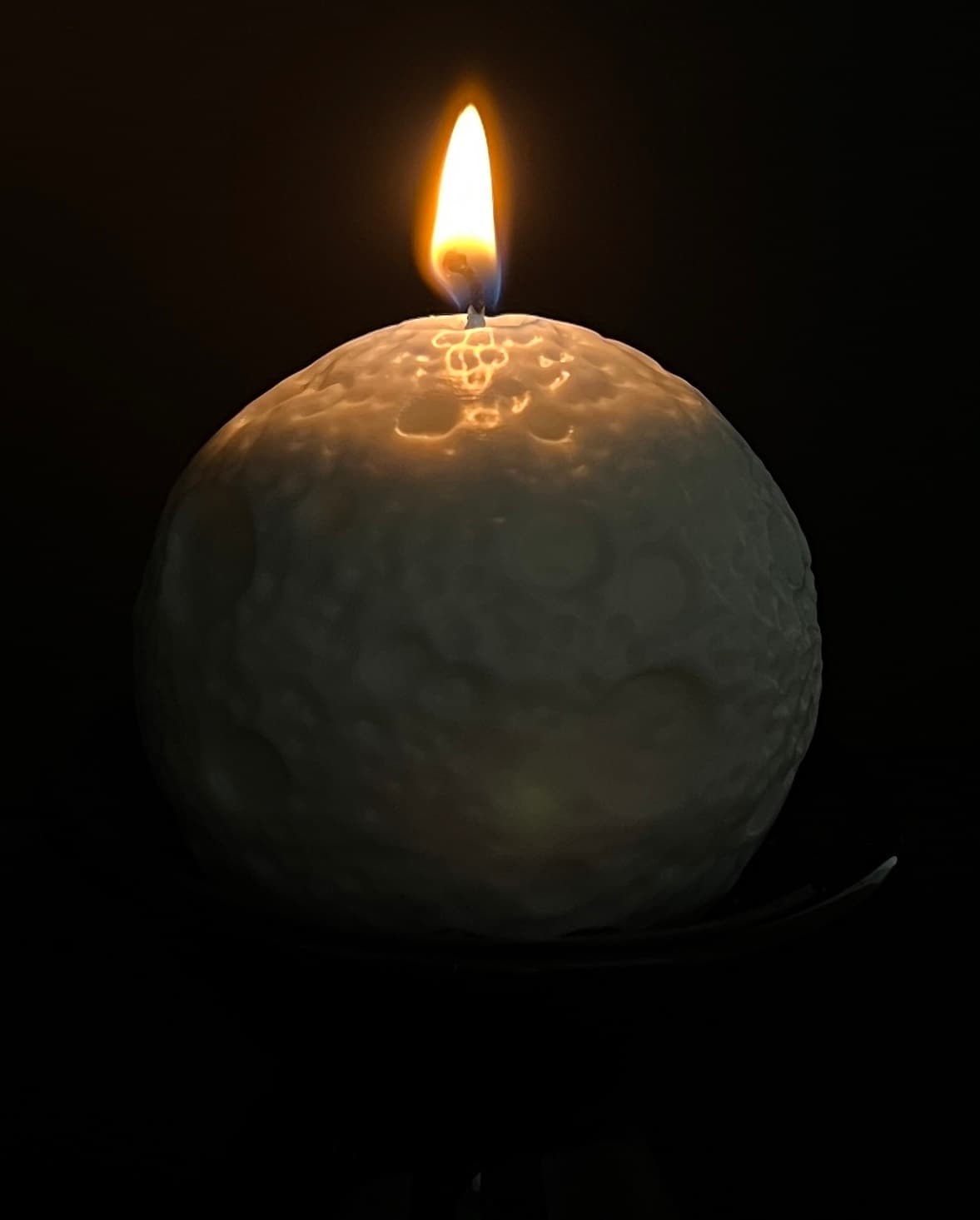 A customer’s lit moon-shaped candle
