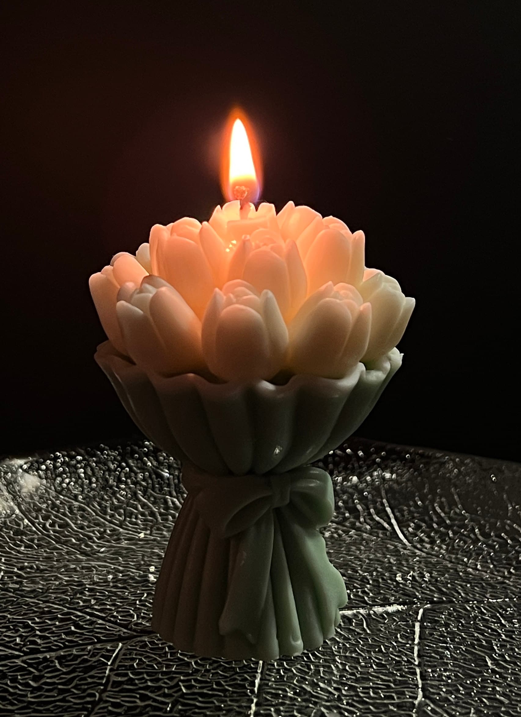 A customer’s lit flower bouquet candle