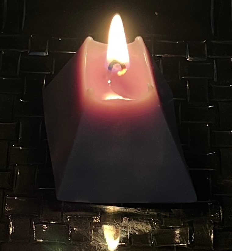 A customer’s lit pillar candle