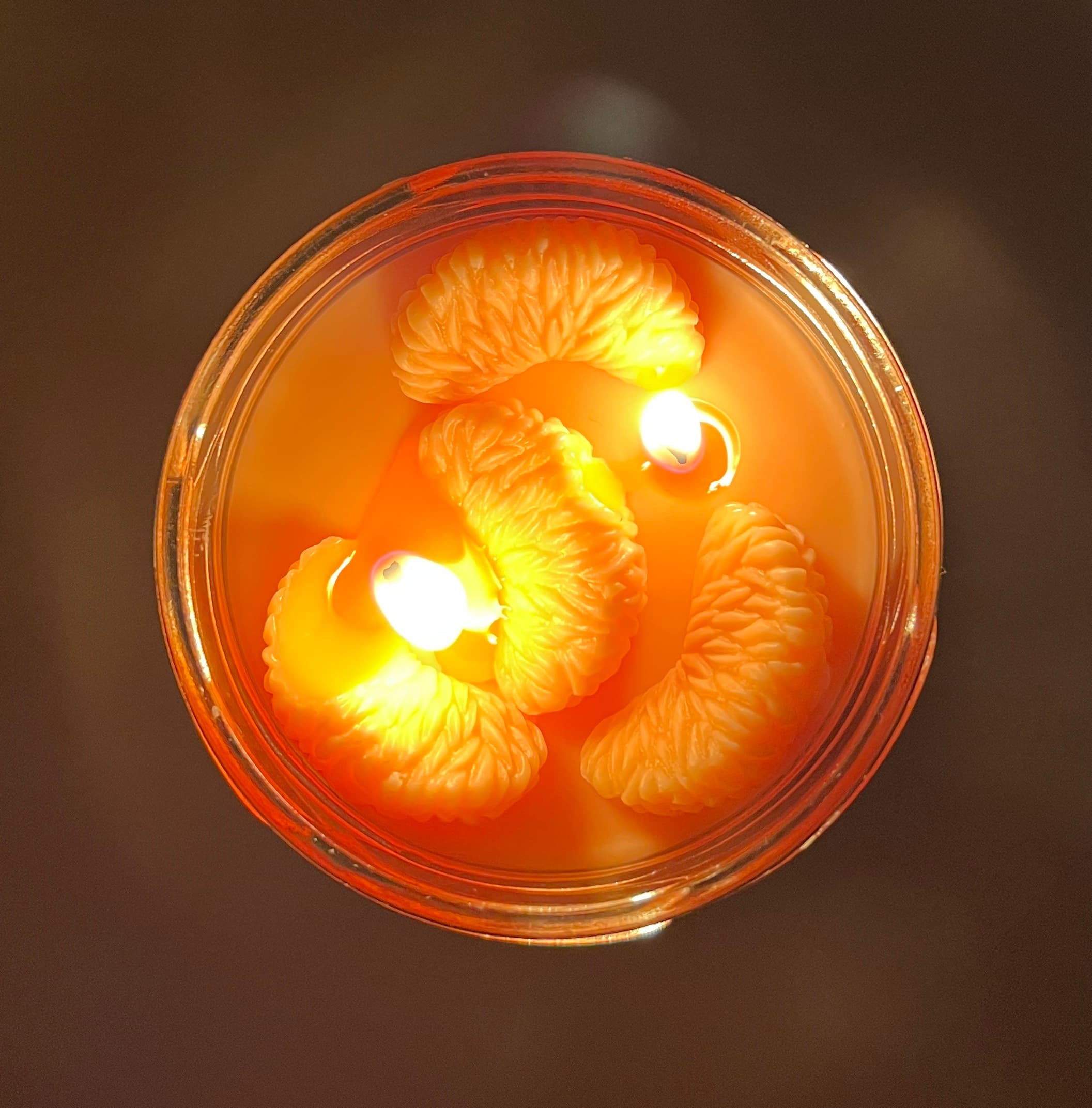 A customer’s lit mandarin segment candle from above