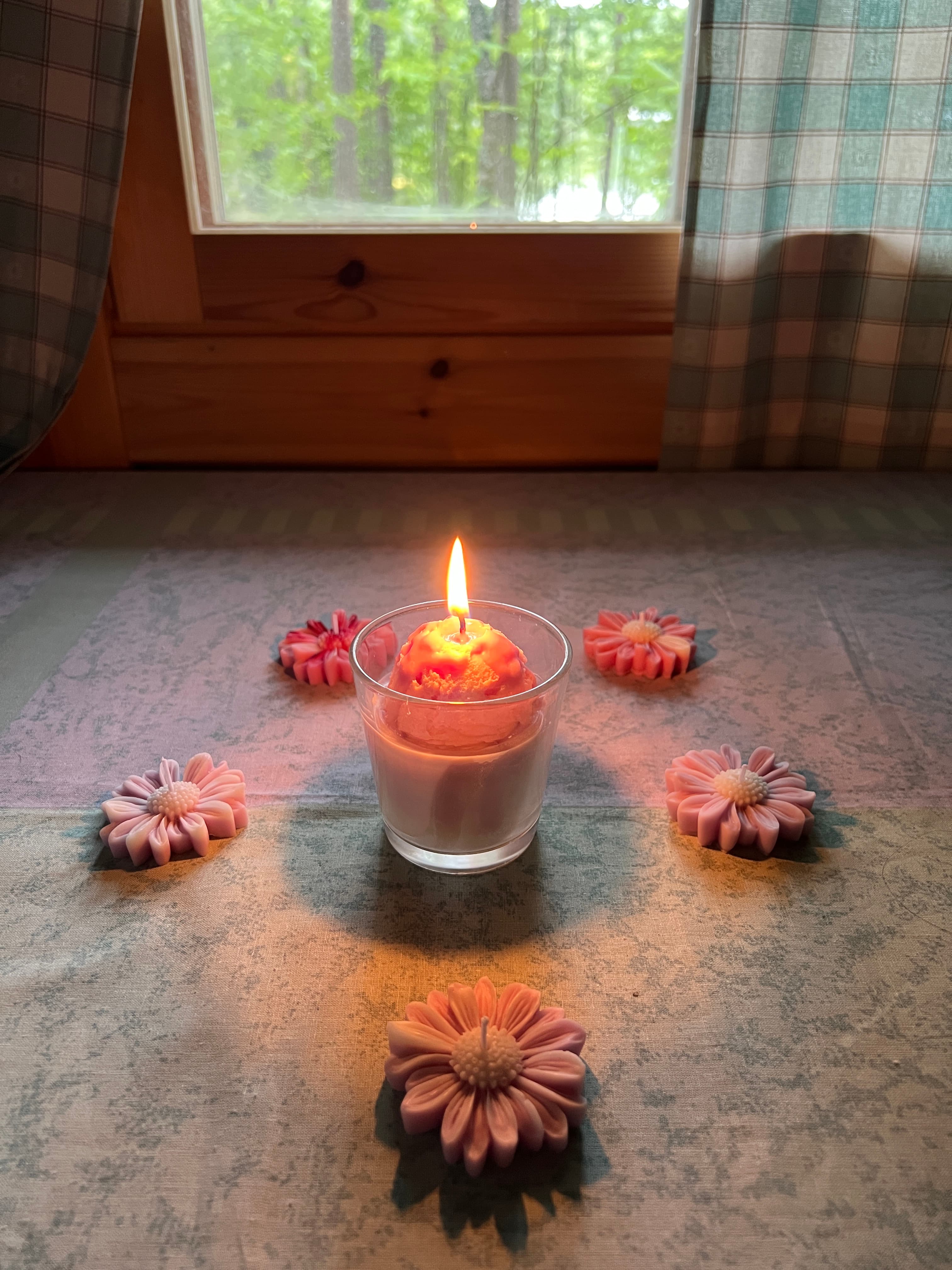 A customer’s lit candle surrounded by flower candles